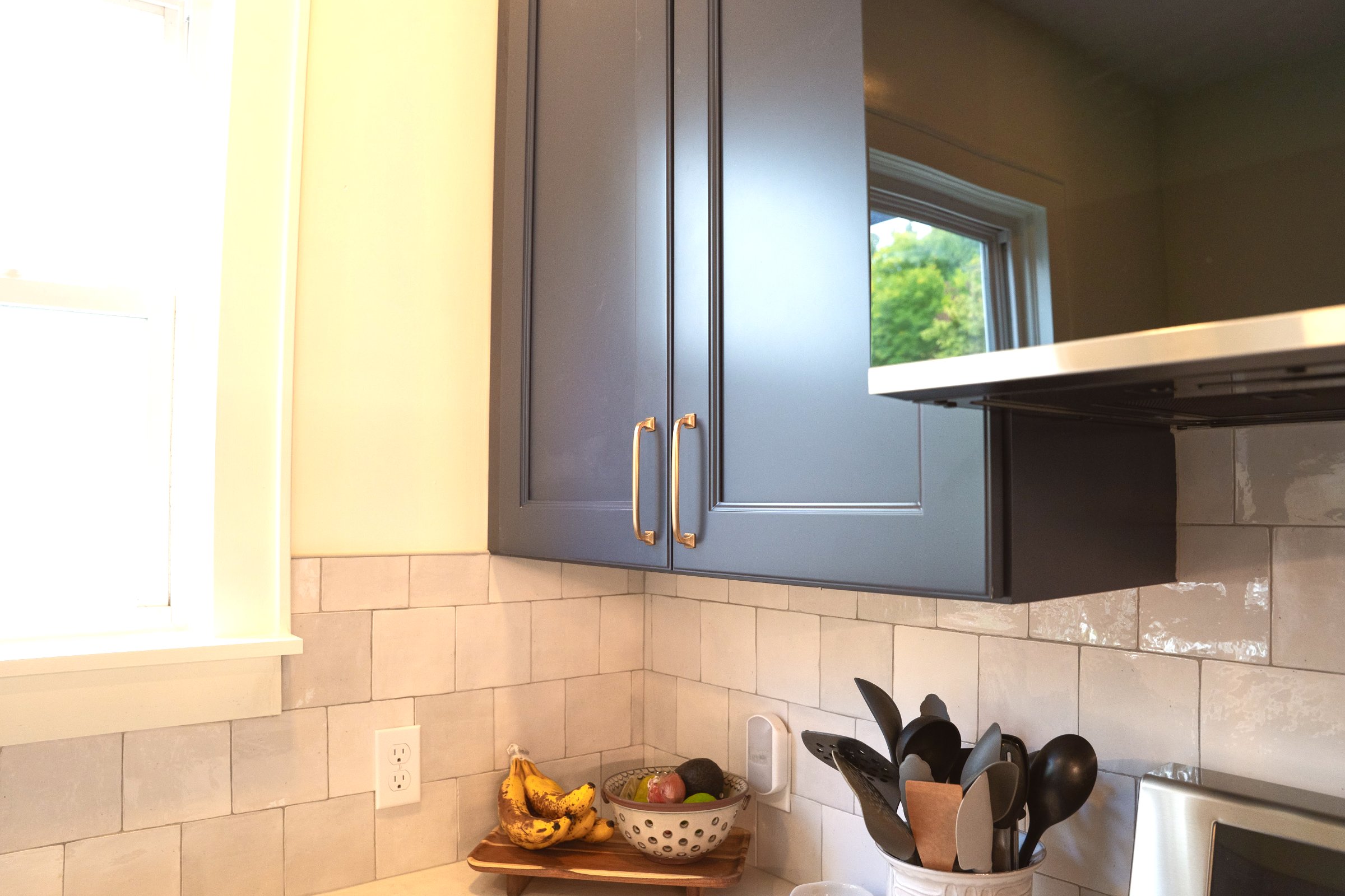 Kitchen remodel — navy cabinets, white quartz island, pendant lighting